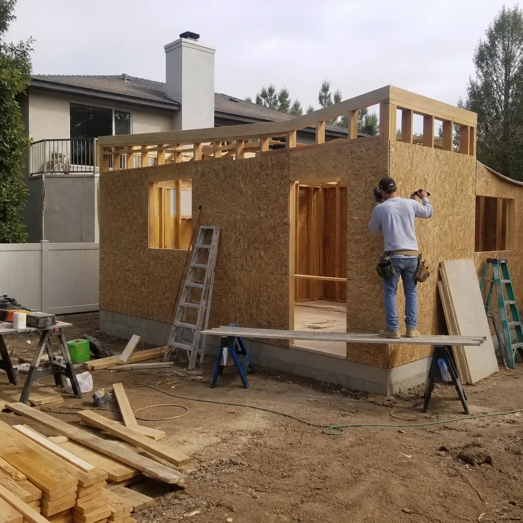 Contractor installing plywood panels on an ADU residential room addition